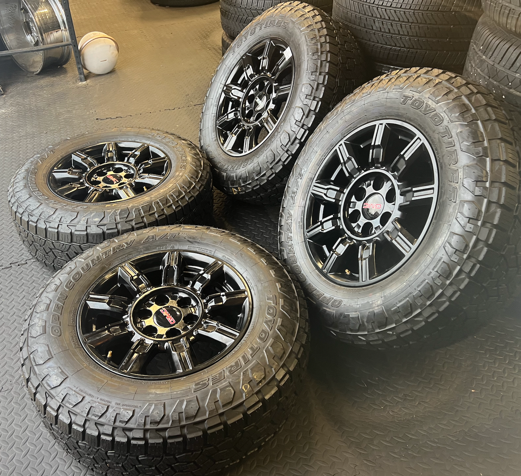 OEM 18” Gloss Black Wheels wrapped in Toyo Open Country A/T tires.