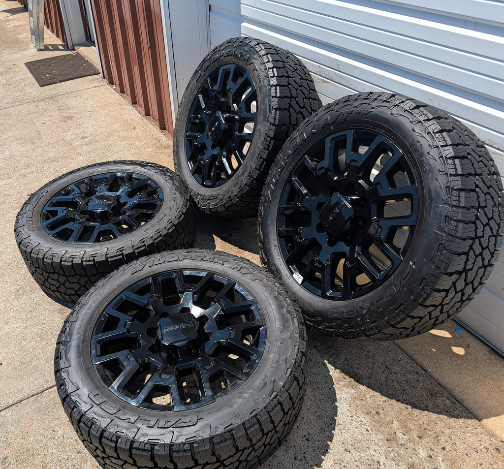 OEM 22” Gloss Black GMC HD Wheels with Split-Spoke Design wrapped in LT285/55R22 Falken Wildpeak A/T4W tires.