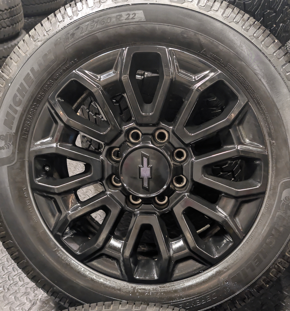 OEM 22” Gloss Black Chevrolet Silverado 2500HD / 3500HD Wheels wrapped in Michelin Defender LTX tires.