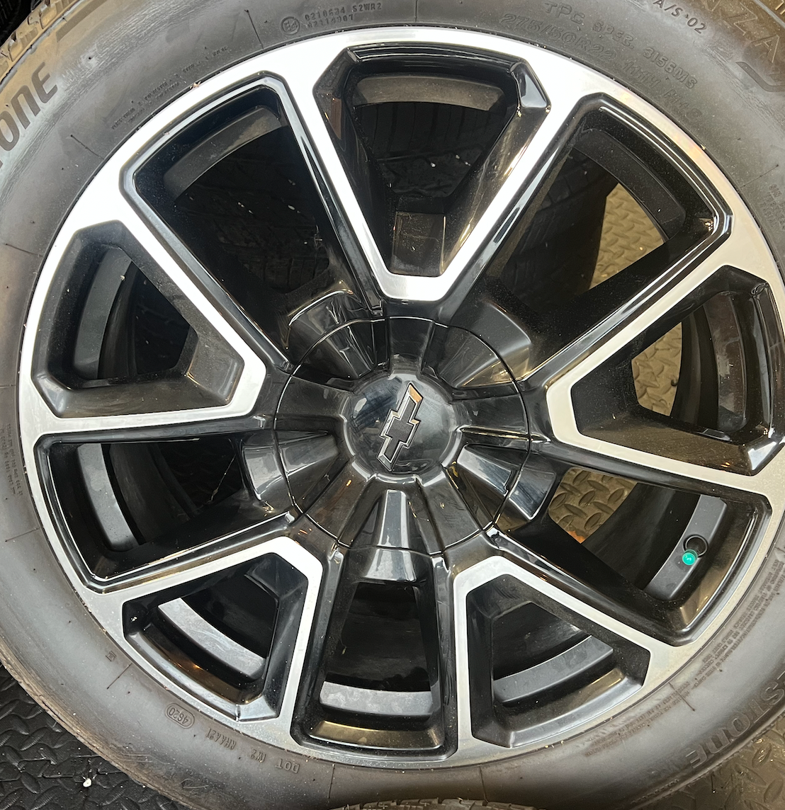 OEM 22” Black Machined Chevrolet Tahoe/Suburban Wheels wrapped in Bridgestone tires.