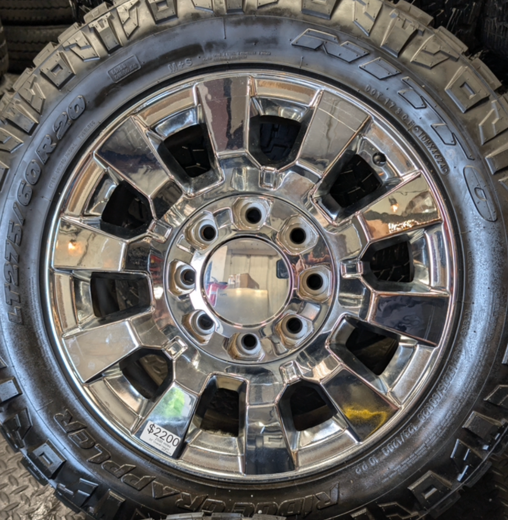 OEM 20” Chrome GMC Sierra Denali 2500HD / 3500HD Wheels wrapped in LT275/60R20 Nitto Ridge Grappler tires.