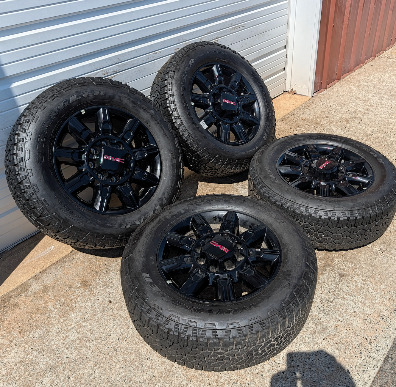 OEM 20” GMC Sierra 2500HD / 3500HD AT4 Black Wheels wrapped in Goodyear Wrangler TrailRunner A/T tires.