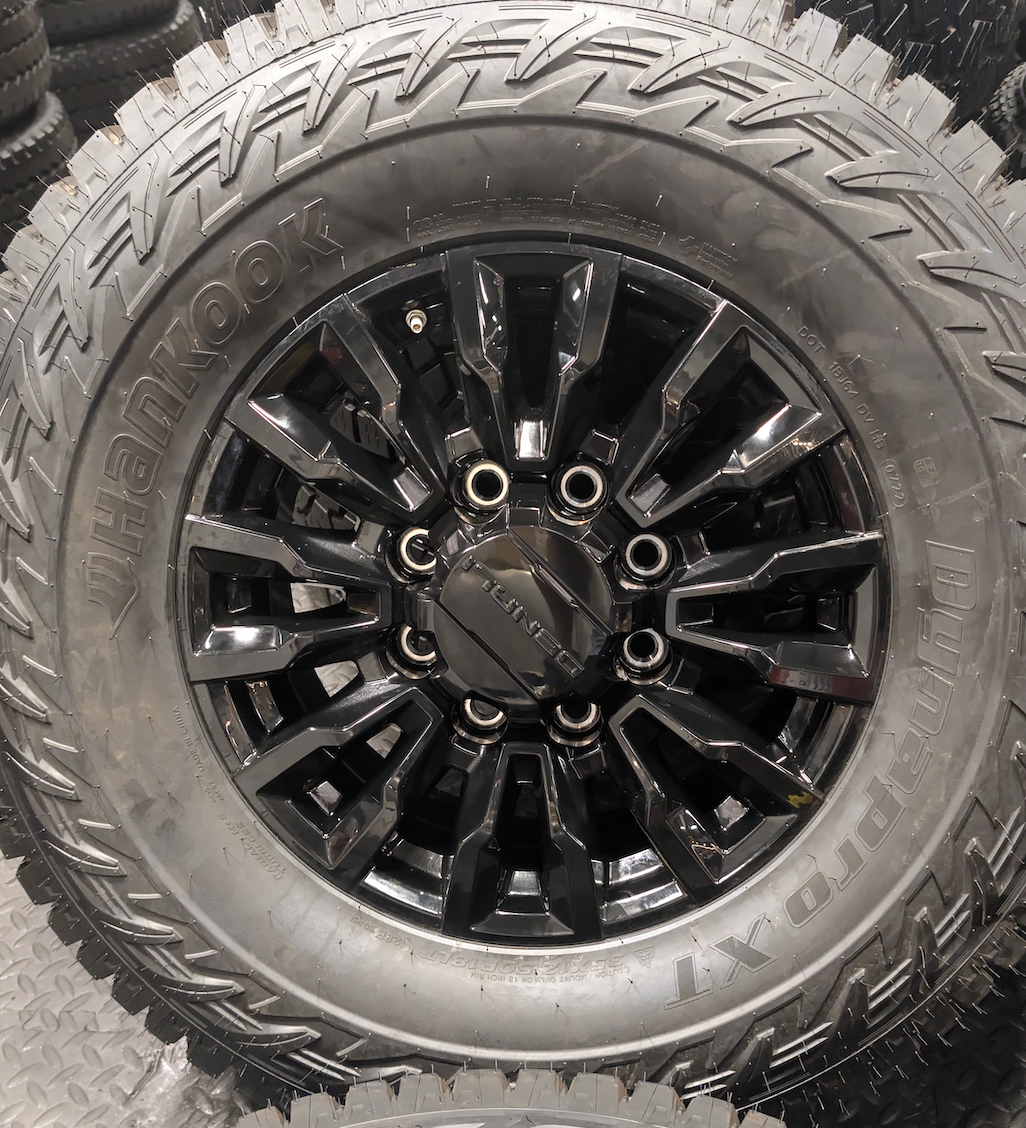 OEM 18” Gloss Black GMC Sierra / Chevrolet Silverado 2500HD & 3500HD Wheels wrapped in Hankook Dynapro XT tires.