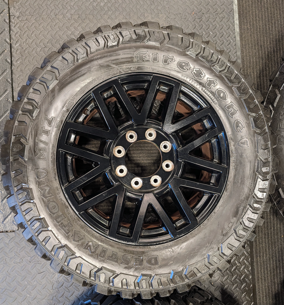 OEM 20” Gloss Black Ford F-250 / F-350 Super Duty Wheels wrapped in Firestone Destination M/T2 tires.