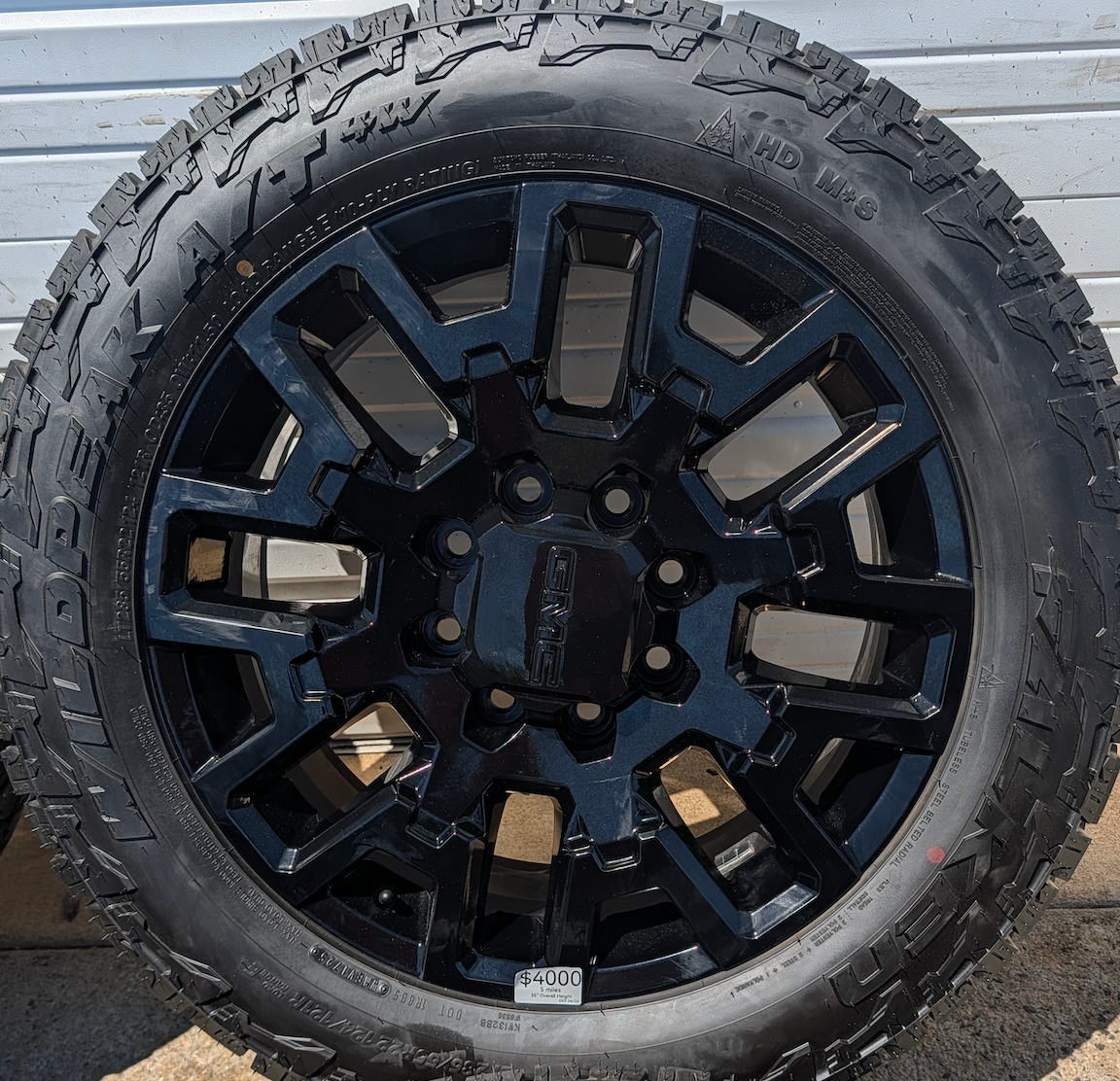 OEM 22” Gloss Black GMC HD Wheels with Split-Spoke Design wrapped in LT285/55R22 Falken Wildpeak A/T4W tires.
