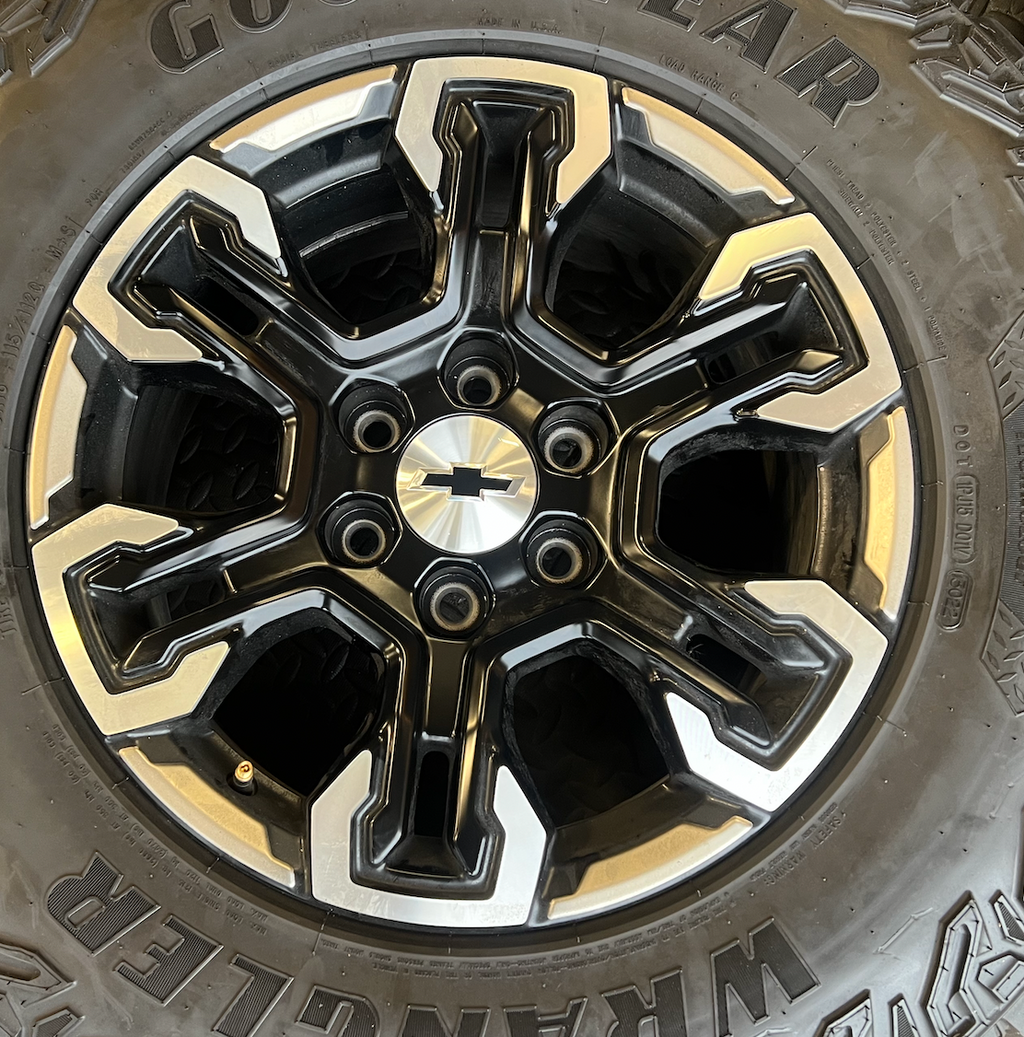 OEM 18” Gloss Black Machined Face Chevrolet Wheels wrapped in Goodyear Wrangler Territory M/T tires.