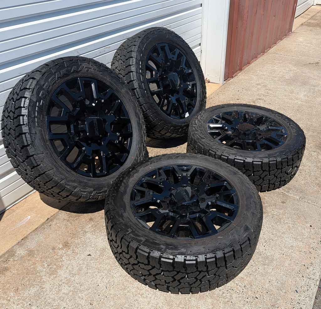 OEM 22” Gloss Black GMC HD Wheels with Split-Spoke Design wrapped in LT285/55R22 Falken Wildpeak A/T4W tires.
