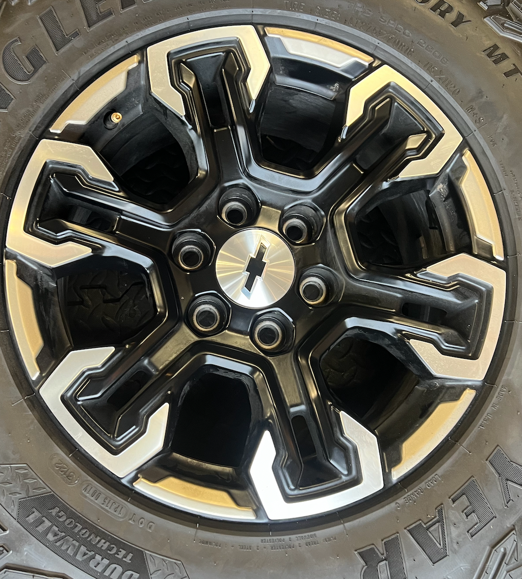 OEM 18” Gloss Black Machined Face Chevrolet Wheels wrapped in Goodyear Wrangler Territory M/T tires.