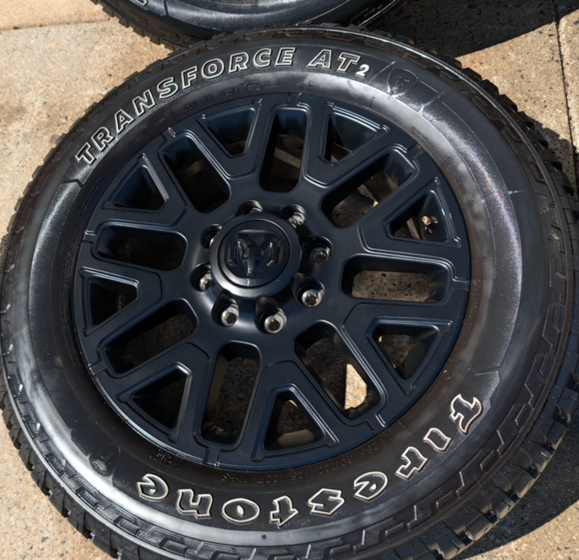 OEM 20” Matte Black Dodge RAM 2500 / 3500 Wheels wrapped in LT285/60R20 Firestone Transforce AT2 tires.