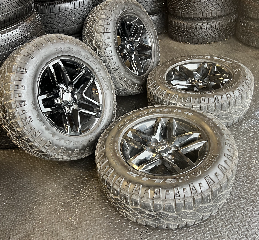 OEM 18” Gloss Black Trail Boss Wheels wrapped in Goodyear Wrangler Duratrac tires.