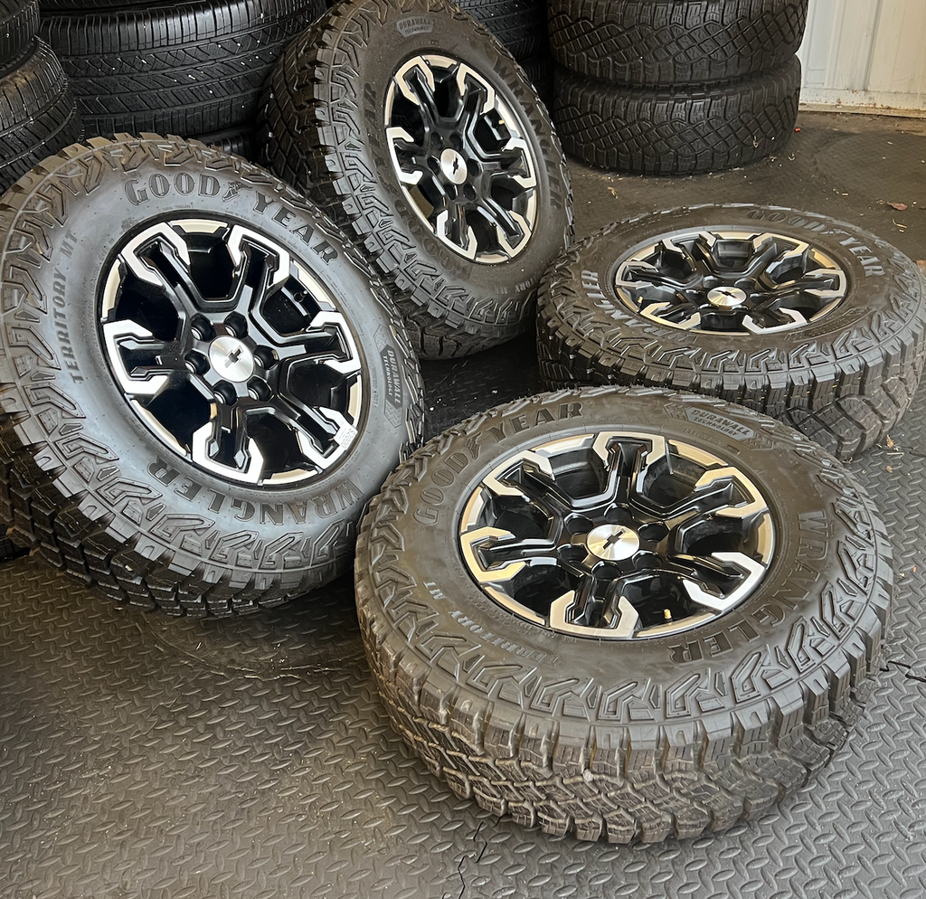 OEM 18” Gloss Black Machined Face Chevrolet Wheels wrapped in Goodyear Wrangler Territory M/T tires.