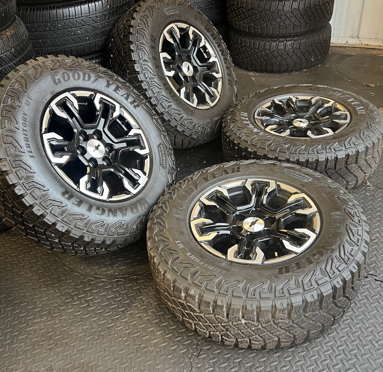 OEM 18” Gloss Black Machined Face Chevrolet Wheels wrapped in Goodyear Wrangler Territory M/T tires.