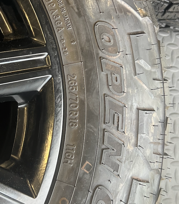 OEM 18” Gloss Black Wheels wrapped in Toyo Open Country A/T tires.