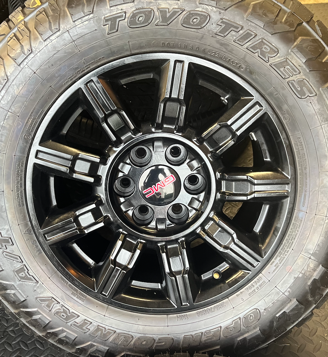 OEM 18” Gloss Black Wheels wrapped in Toyo Open Country A/T tires.