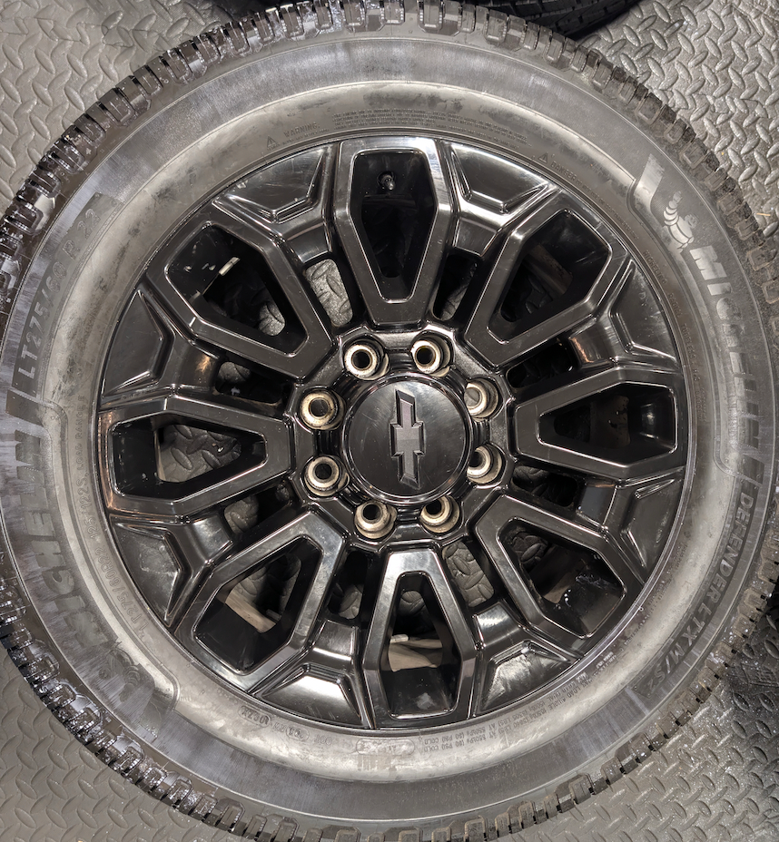 OEM 22” Gloss Black Chevrolet Silverado 2500HD / 3500HD Wheels wrapped in Michelin Defender LTX tires.