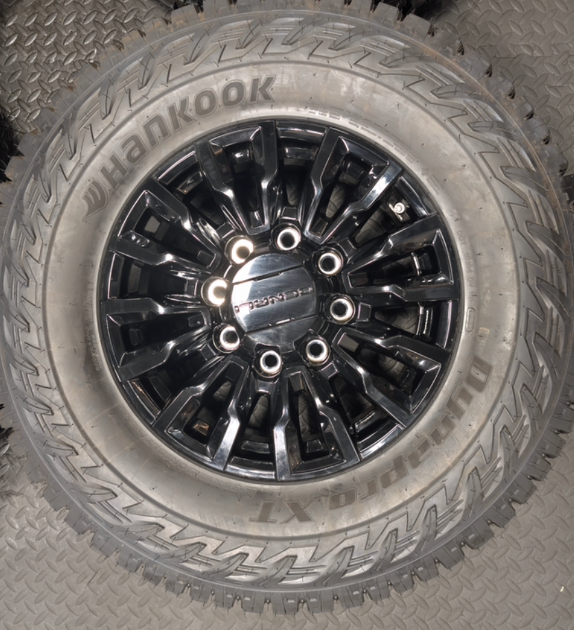 OEM 18” Gloss Black GMC Sierra / Chevrolet Silverado 2500HD & 3500HD Wheels wrapped in Hankook Dynapro XT tires.