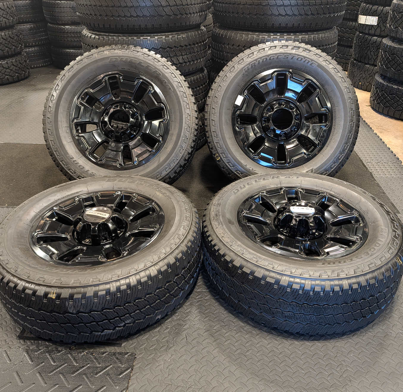 OEM 18” Ford F-250 / F-350 Tremor Wheels with Gloss Black Finish wrapped in Bridgestone Dueler A/T tires.