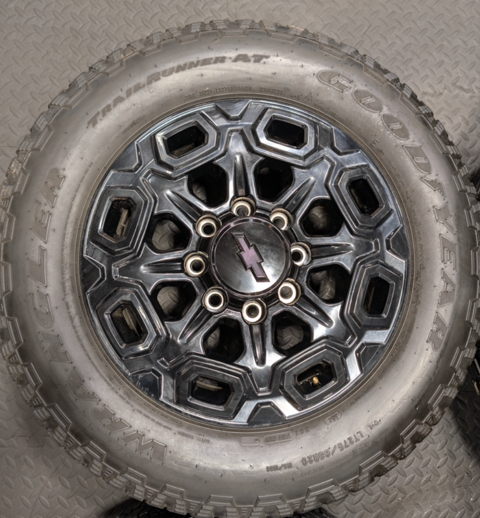 OEM 20” Gloss Black Chevrolet Silverado / GMC Sierra 2500HD & 3500HD Wheels wrapped in LT275/65R20 Goodyear Wrangler TrailRunner A/T tires.