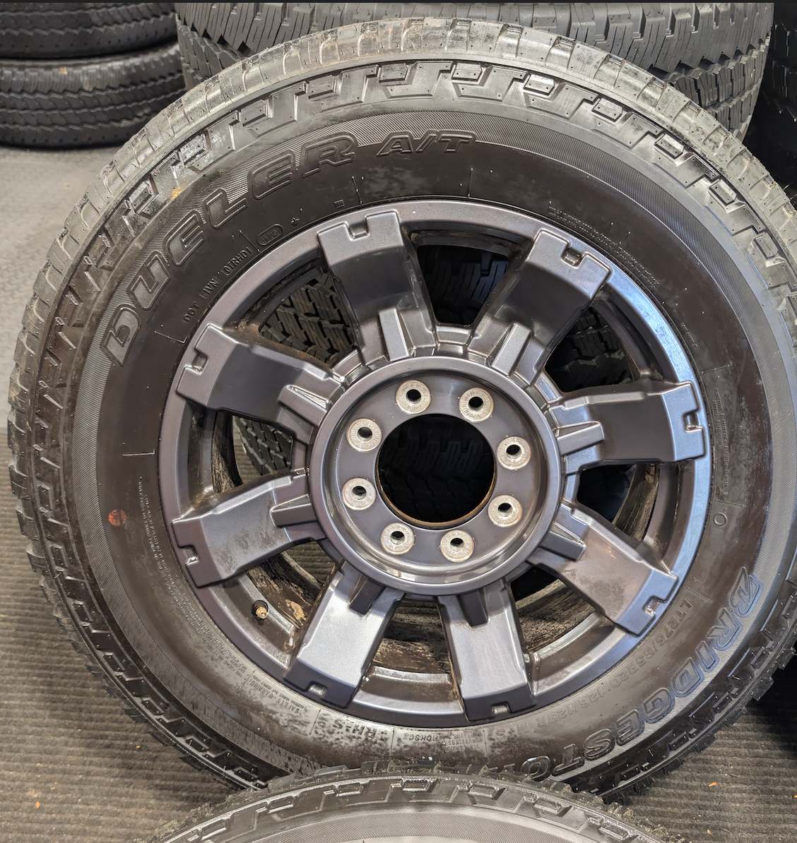 OEM 20” Dark Carbonized Gray Ford F-250 / F-350 Super Duty Wheels wrapped in Bridgestone Dueler tires.