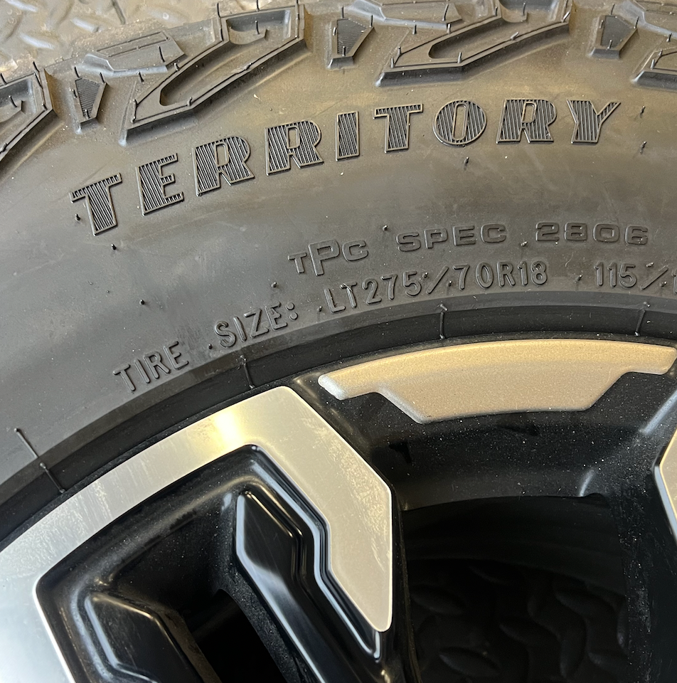 OEM 18” Gloss Black Machined Face Chevrolet Wheels wrapped in Goodyear Wrangler Territory M/T tires.