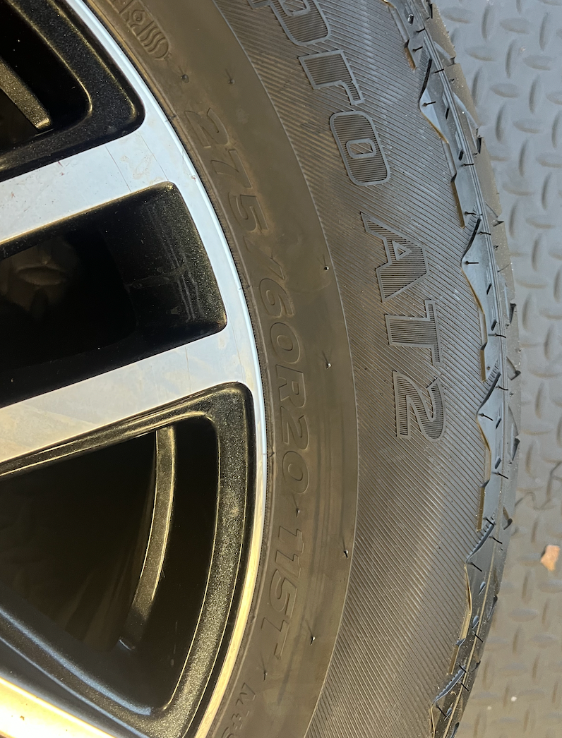 OEM 20” Gloss Black Wheels with Silver Inserts / Accents wrapped in Hankook Dynapro AT2 tires.