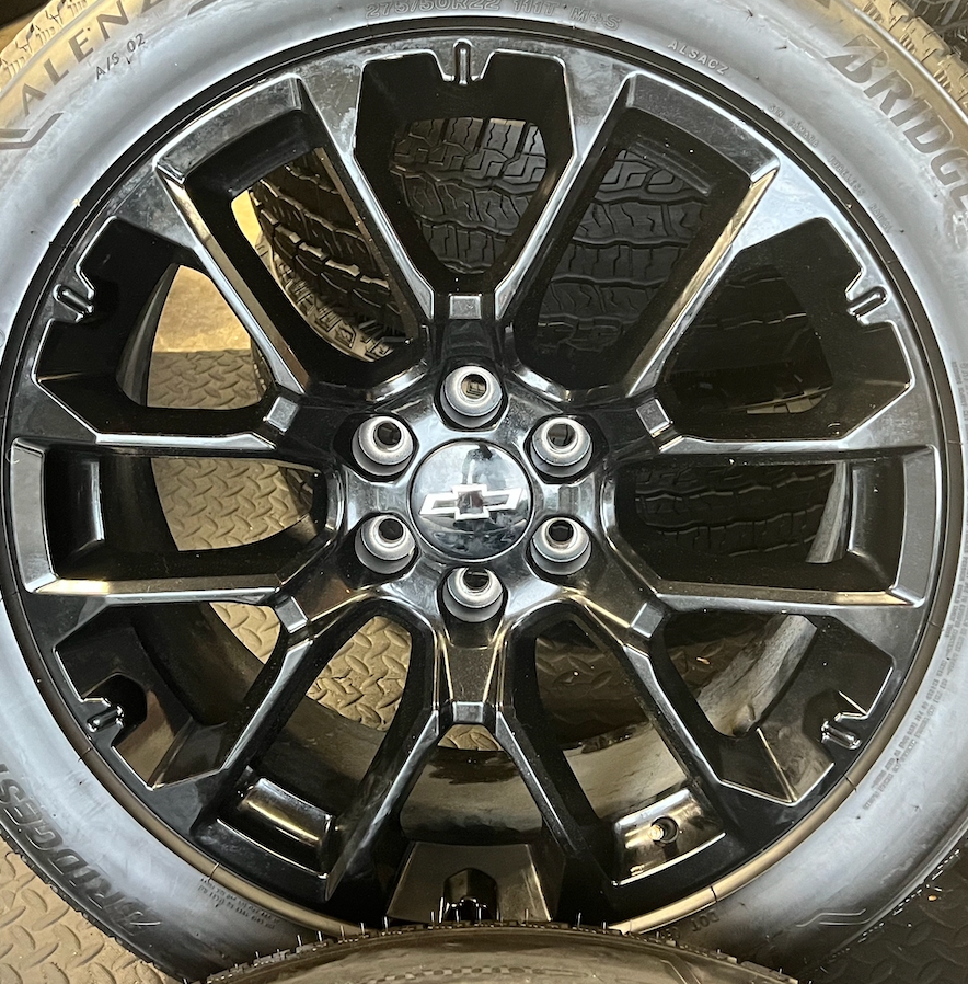 OEM 22” Gloss Black Replica Wheels wrapped in Bridgestone tires.
