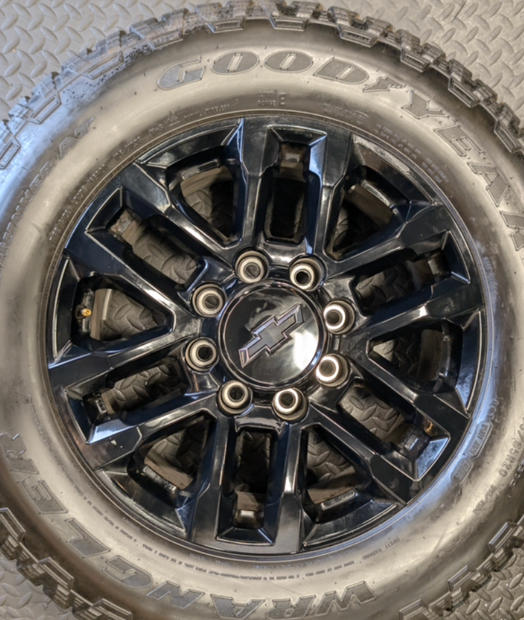OEM 20” Gloss Black Chevrolet Silverado / GMC Sierra 2500HD & 3500HD Wheels wrapped in LT275/65R20 Goodyear Wrangler TrailRunner A/T tires.
