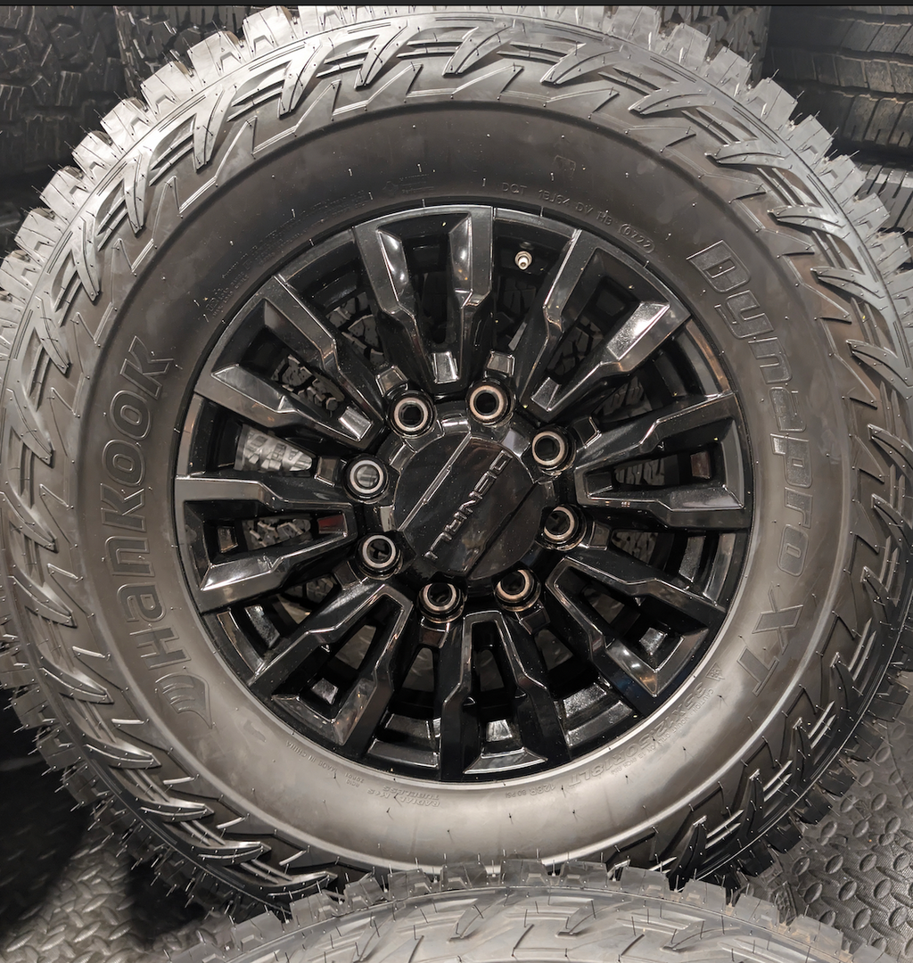OEM 18” Gloss Black GMC Sierra / Chevrolet Silverado 2500HD & 3500HD Wheels wrapped in Hankook Dynapro XT tires.