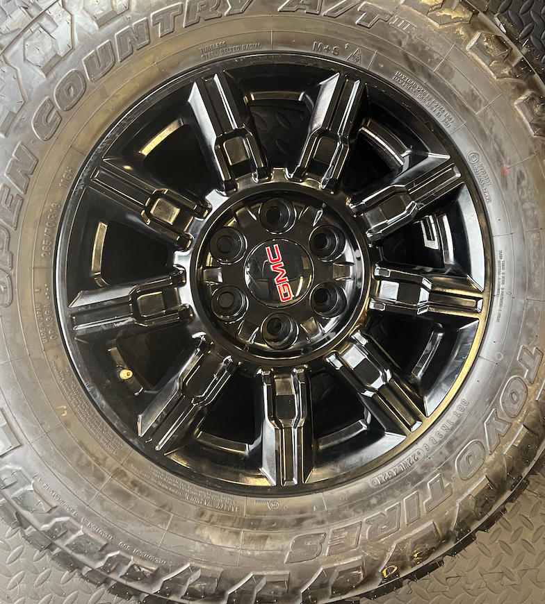 OEM 18” Gloss Black Wheels wrapped in Toyo Open Country A/T tires.