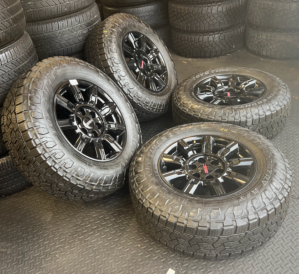OEM 18” Gloss Black Wheels wrapped in Toyo Open Country A/T tires.
