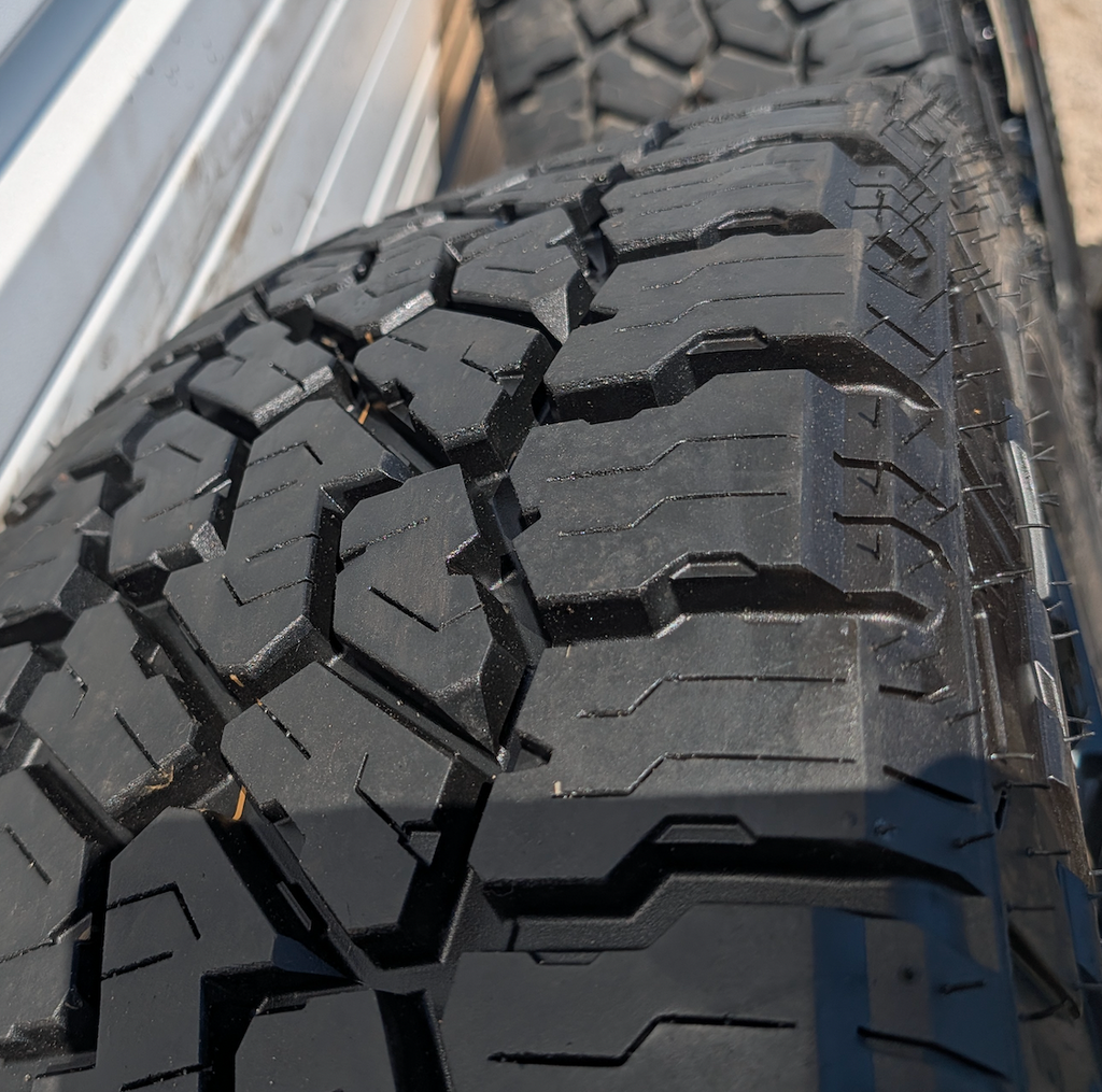 OEM 22” Gloss Black GMC HD Wheels with Split-Spoke Design wrapped in LT285/55R22 Falken Wildpeak A/T4W tires.