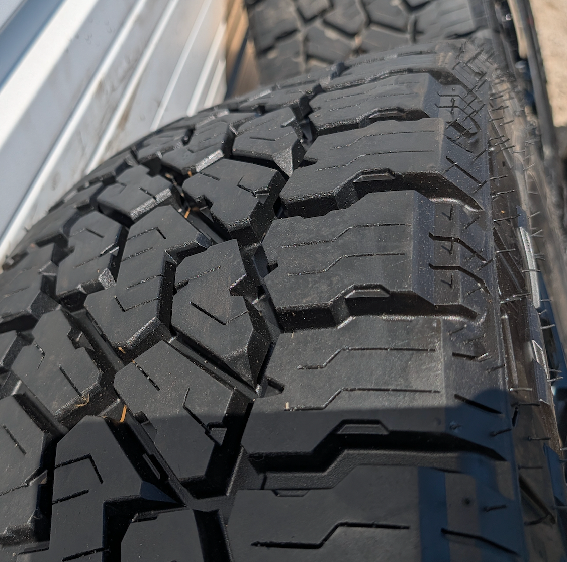OEM 22” Gloss Black GMC HD Wheels with Split-Spoke Design wrapped in LT285/55R22 Falken Wildpeak A/T4W tires.