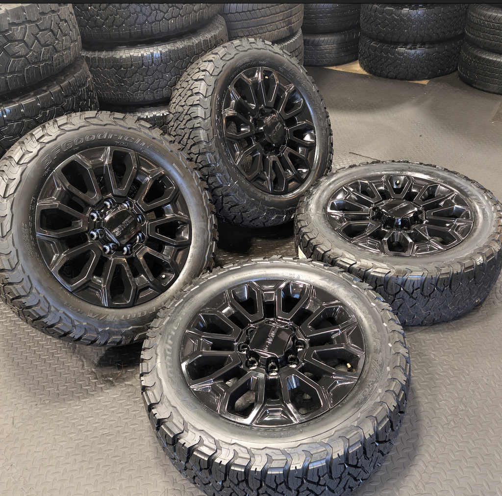 OEM 22” Gloss Black GMC Sierra 2500HD / 3500HD Wheels wrapped in BFGoodrich All-Terrain T/A KO2/KO3 tires.
