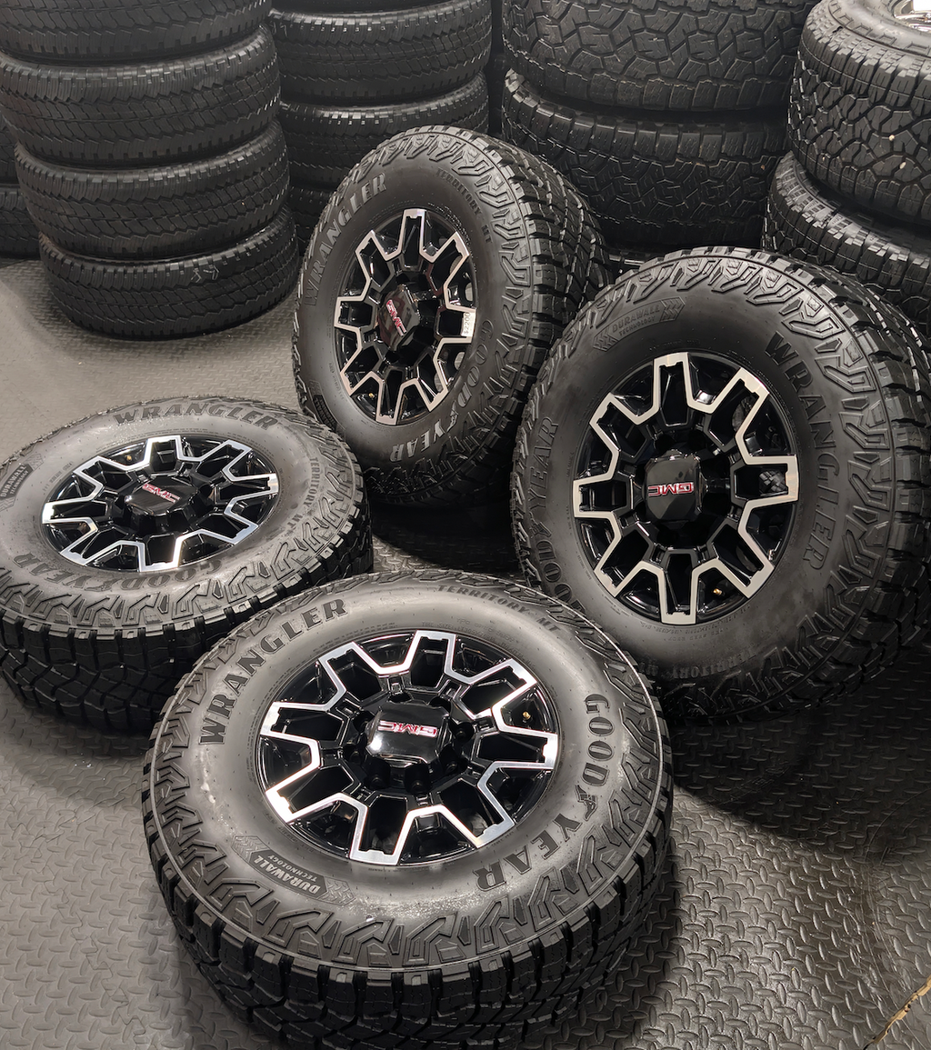 OEM 18” GMC Sierra 2500HD AT4X Black Wheels wrapped in Goodyear Wrangler Territory M/T tires.