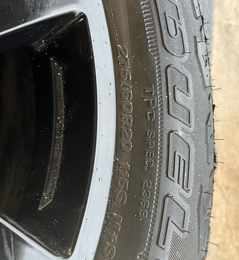 OEM 20” Gloss Black Wheels wrapped in Bridgestone Dueler A/T tires.