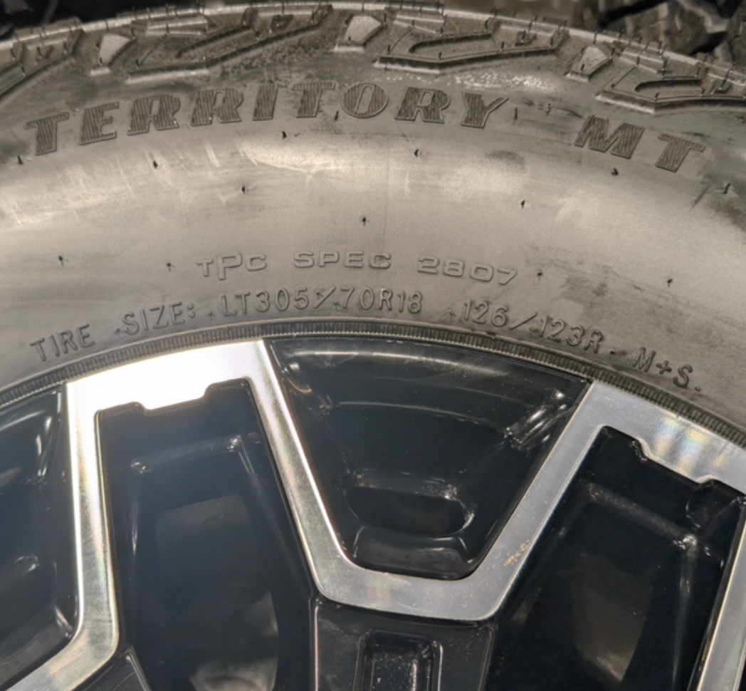 OEM 18” GMC Sierra 2500HD AT4X Black Wheels wrapped in Goodyear Wrangler Territory M/T tires.