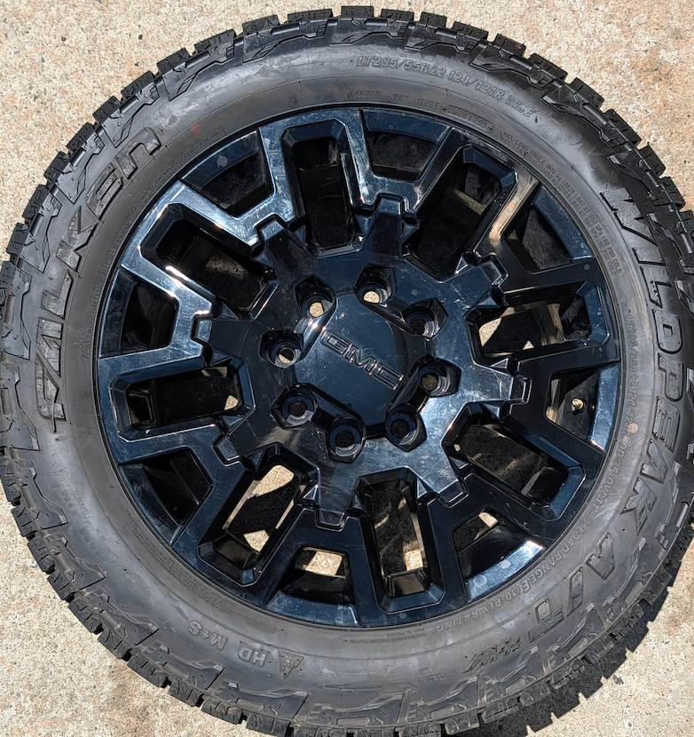 OEM 22” Gloss Black GMC HD Wheels with Split-Spoke Design wrapped in LT285/55R22 Falken Wildpeak A/T4W tires.