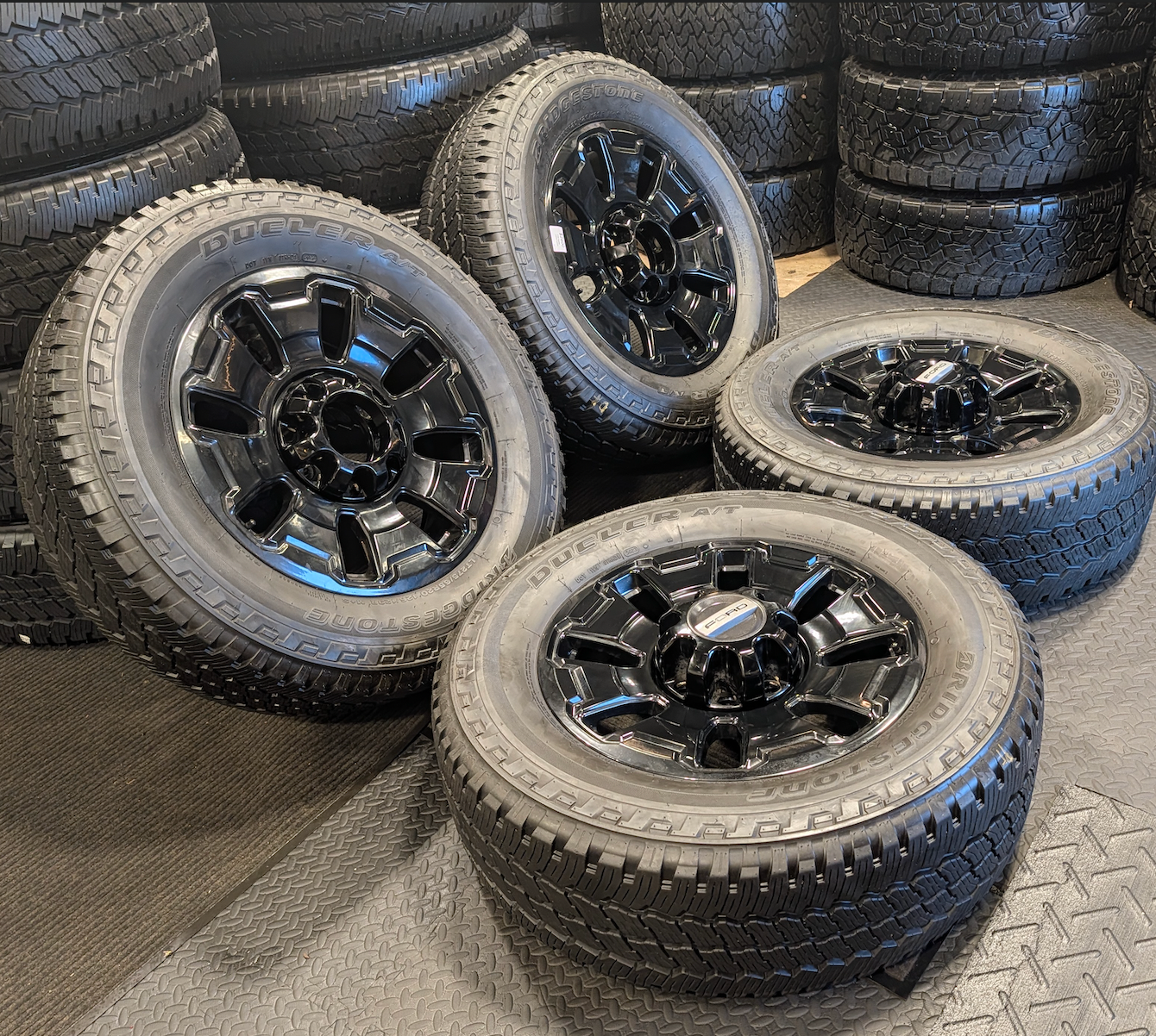 OEM 18” Ford F-250 / F-350 Tremor Wheels with Gloss Black Finish wrapped in Bridgestone Dueler A/T tires.