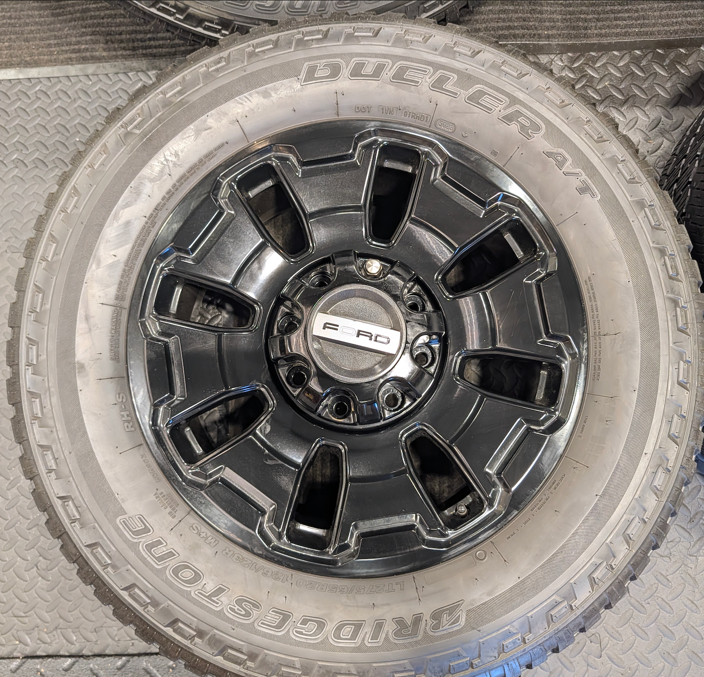 OEM 18” Ford F-250 / F-350 Tremor Wheels with Gloss Black Finish wrapped in Bridgestone Dueler A/T tires.