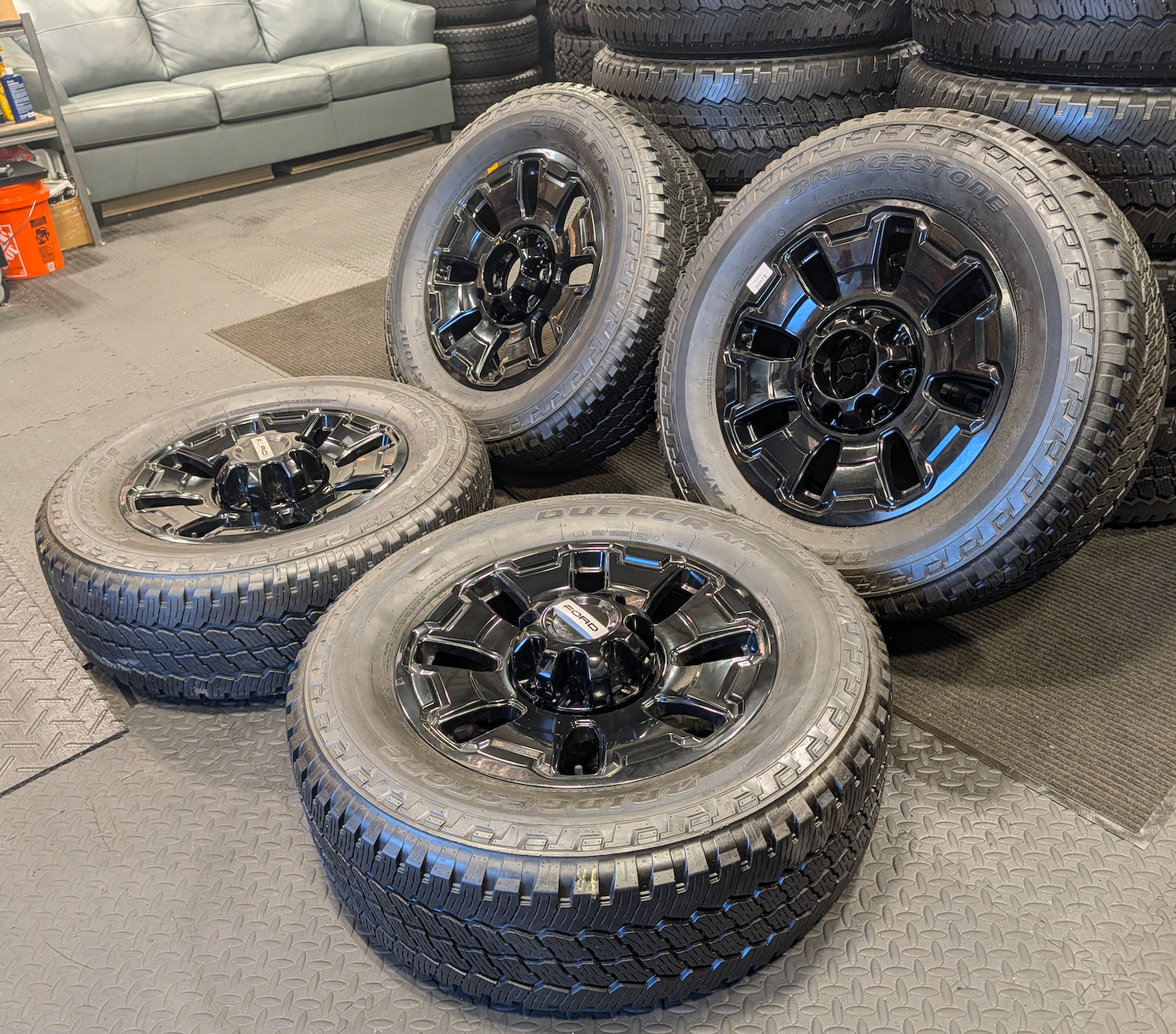 OEM 18” Ford F-250 / F-350 Tremor Wheels with Gloss Black Finish wrapped in Bridgestone Dueler A/T tires.