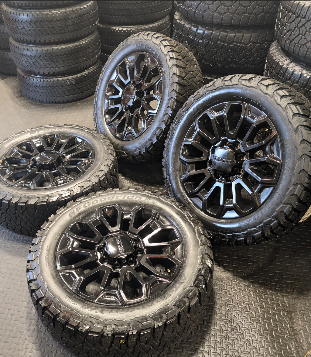 OEM 22” Gloss Black GMC Sierra 2500HD / 3500HD Wheels wrapped in BFGoodrich All-Terrain T/A KO2/KO3 tires.