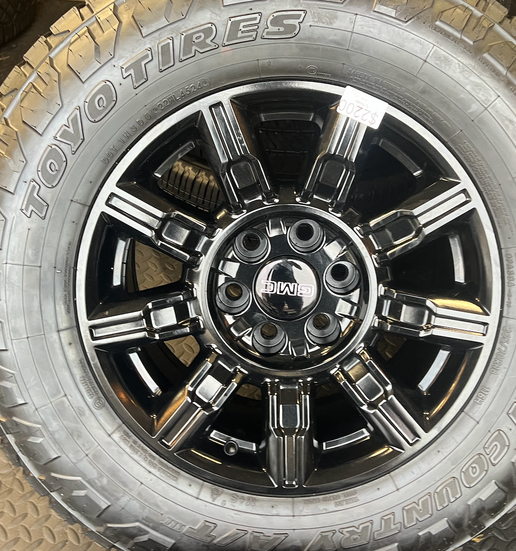 OEM 18” Gloss Black Wheels wrapped in Toyo Open Country A/T tires.
