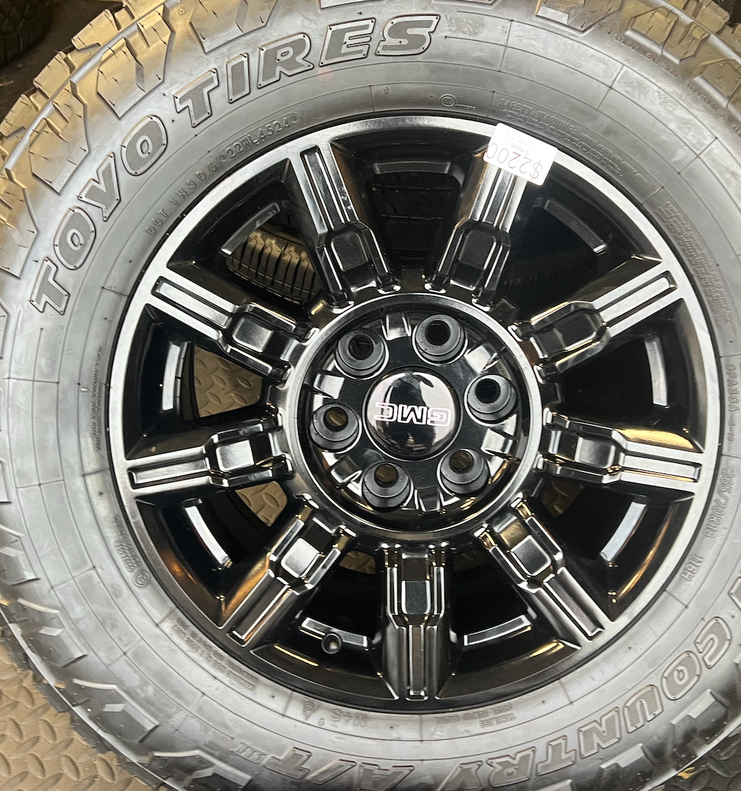 OEM 18” Gloss Black Wheels wrapped in Toyo Open Country A/T tires.