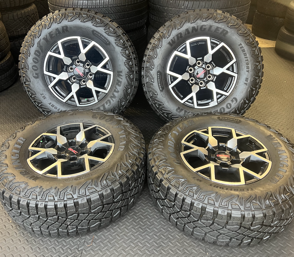 OEM 17”  Wheels with Black & Machined Finish wrapped in Goodyear Wrangler Territory M/T tires.