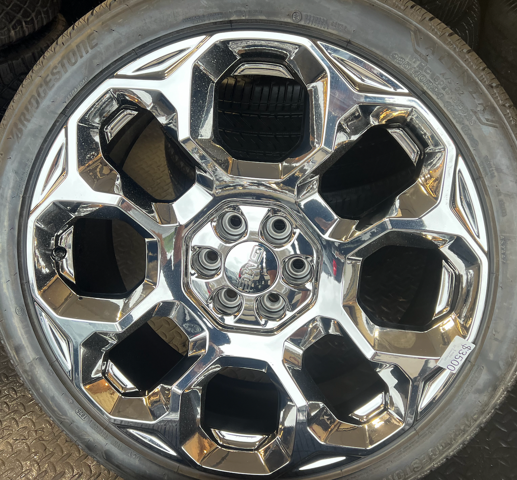 OEM 24” Chrome GMC Wheels wrapped in Bridgestone tires.