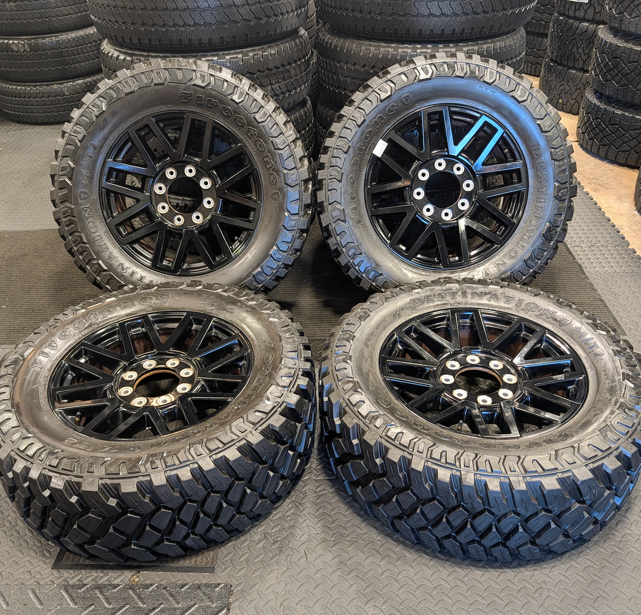 OEM 20” Gloss Black Ford F-250 / F-350 Super Duty Wheels wrapped in Firestone Destination M/T2 tires.