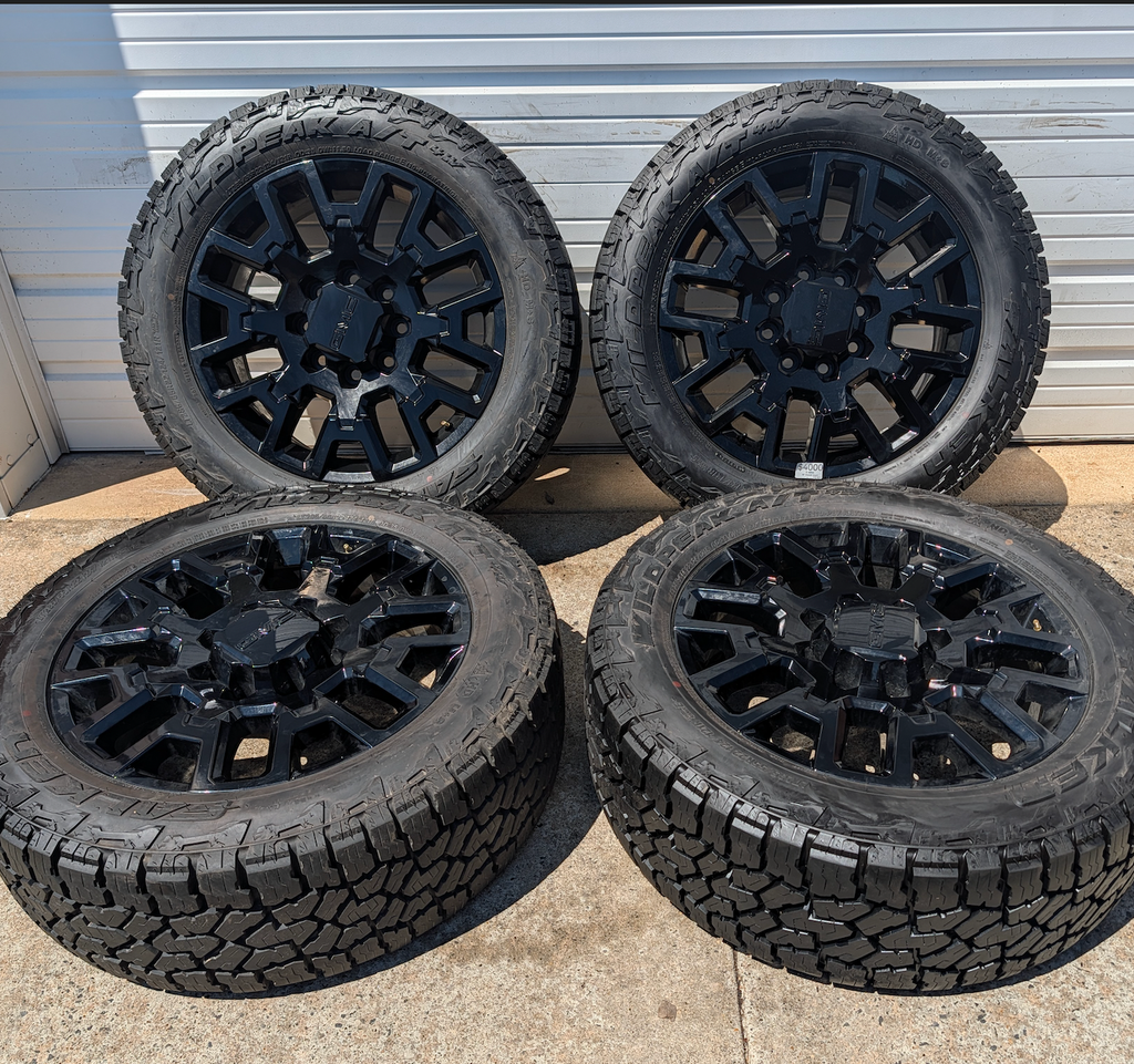 OEM 22” Gloss Black GMC HD Wheels with Split-Spoke Design wrapped in LT285/55R22 Falken Wildpeak A/T4W tires.