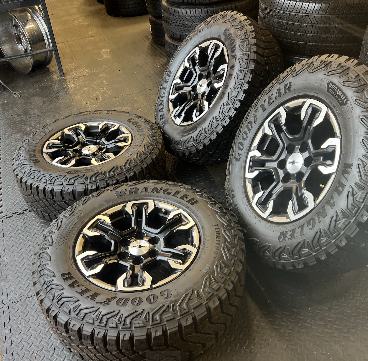 OEM 18” Gloss Black Machined Face Chevrolet Wheels wrapped in Goodyear Wrangler Territory M/T tires.