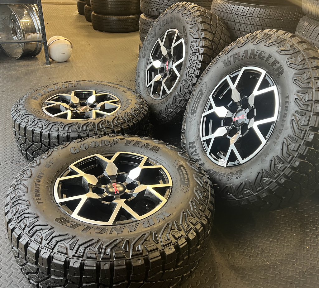 OEM 17”  Wheels with Black & Machined Finish wrapped in Goodyear Wrangler Territory M/T tires.