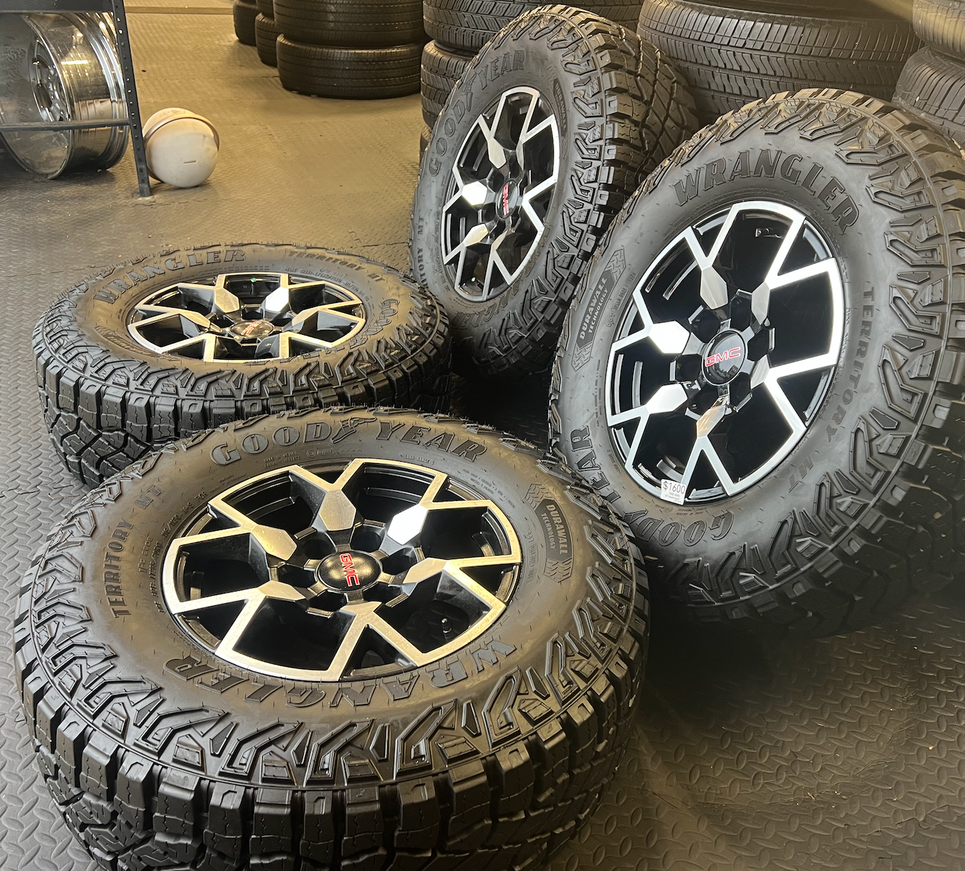 OEM 17”  Wheels with Black & Machined Finish wrapped in Goodyear Wrangler Territory M/T tires.